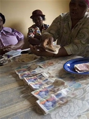 Women count money at a Stokvel meeting in Nhlazuka. (John Robinson, AP file)