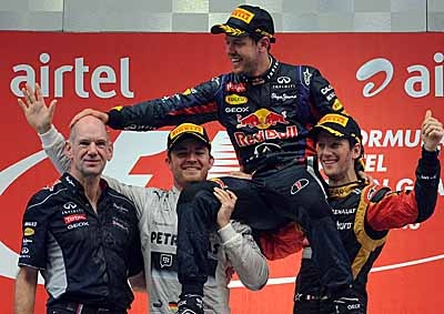 <b>'THANKS, ADRIAN!'</b> Red Bull's Sebastian Vettel, hoisted by Mercedes' Nico Rosberg (left) and Lotus driver Romain Grosjean, pats Red Bull's chief technical officer Adrian Newey after winning the 2013 Indian F1 GP. <i>Image: AFP</i>