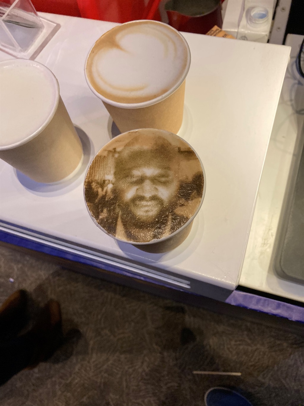 Image of a mans face printed on coffee.