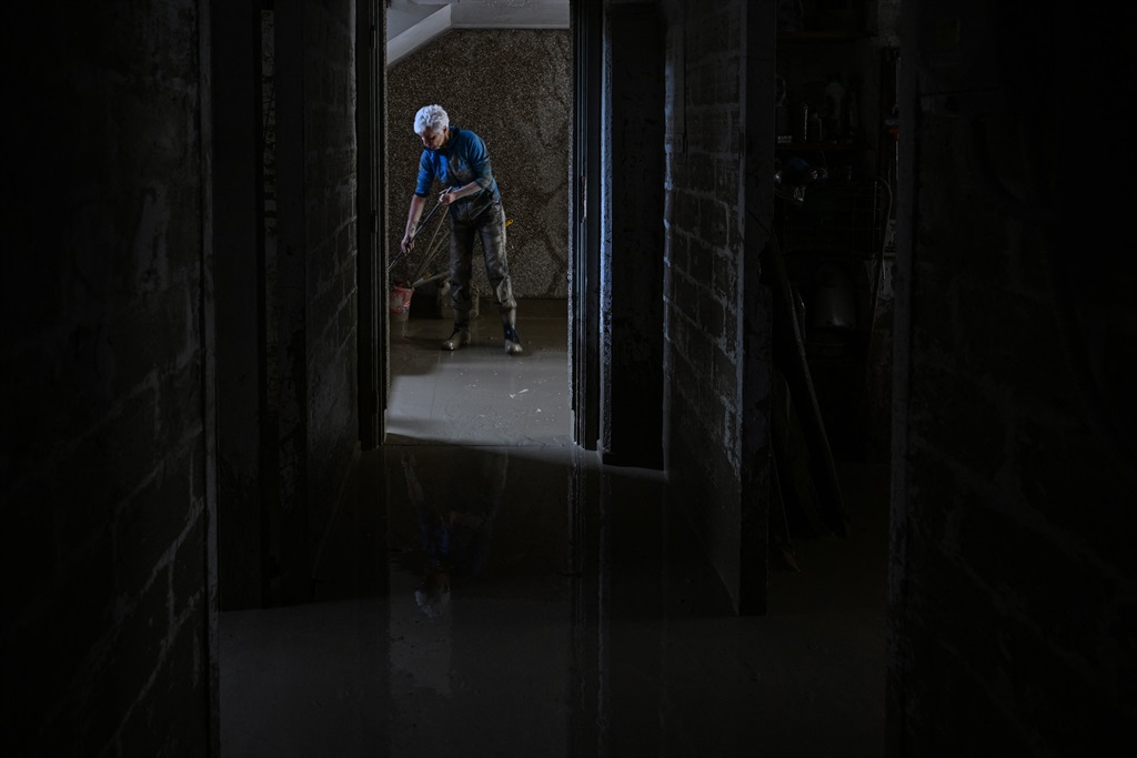 A resident cleans her flooded basement on May 19, 