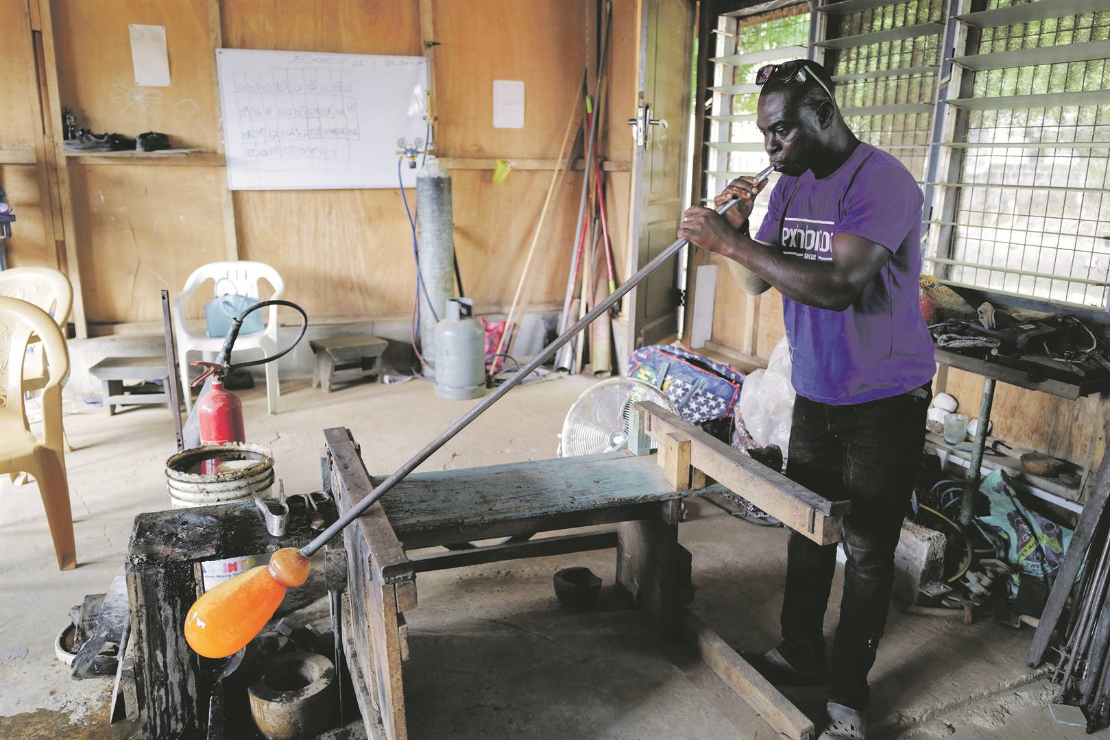 In his workshop, Ghanaian glass-blower Michael Tetteh breathes life into molten recycled glass.