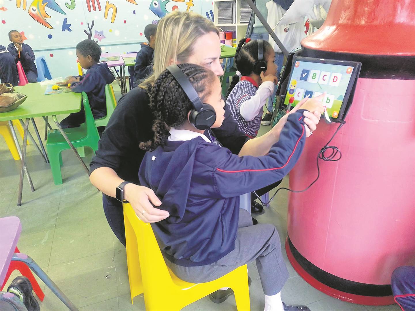 Natalie Roos, managing director at Living Through Learning, shows one of the learners how to effectively use a tablet.PHOTO: Natasha Bezuidenhout