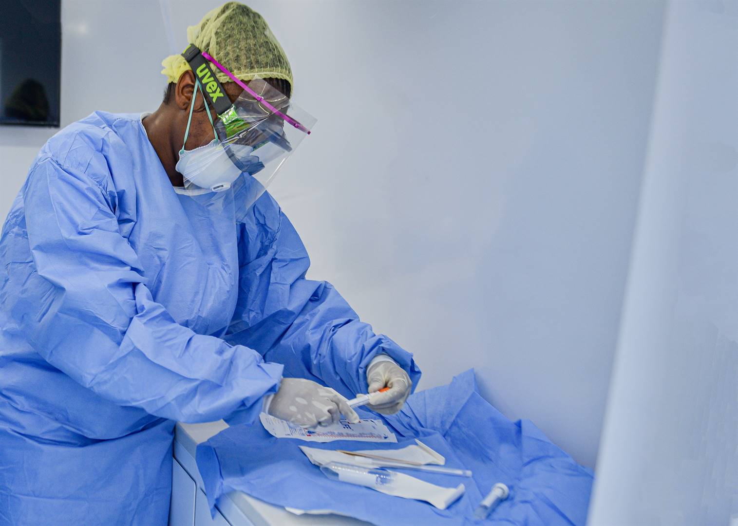 A doctor in protective gear prepares her equipment before testing a patient for Covid 19.