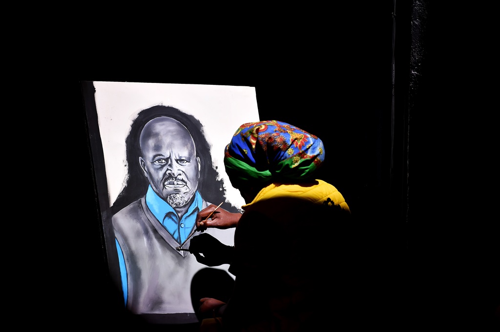 Artist Lebani Rasta Sirenje completes a portrait painting of Shai during the memorial service. Photo by Christopher Moagi 