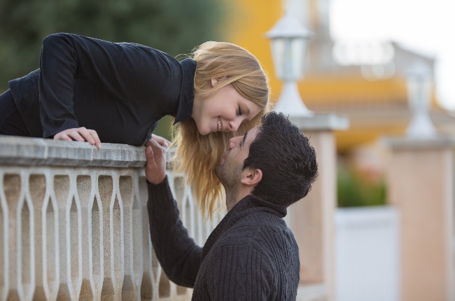 Romantic couple kissing over the ledge of a balcony. (PHOTO: GALLO IMAGES/GETTY IMAGES)