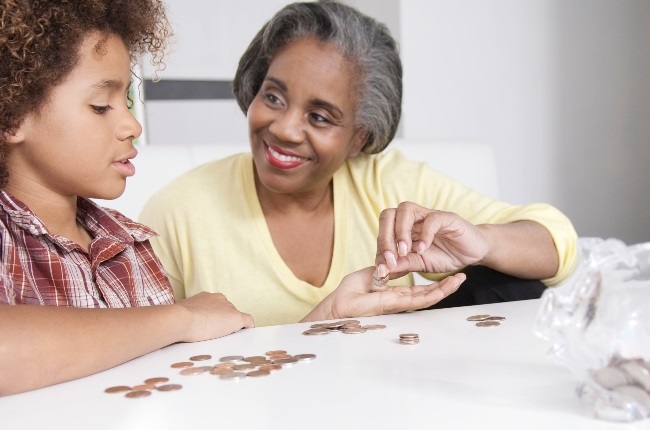 A preteen counting his money with his grandmother.