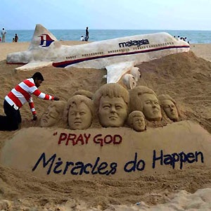 Indian sand artist Sudersan Pattnaik gives final touches on a sand sculpture at Puri beach with a message of prayers for the missing Malaysian Airlines flight MH370. AFP