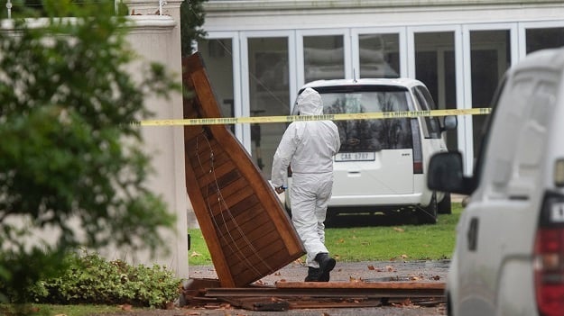 Police scrub the scene of the killing of four people in Constantia on Thursday. 