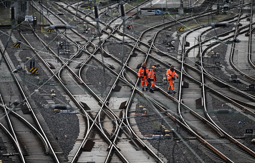 In this file photo taken on March 24, 2023 workers walk on train tracks of German railway operator Deutsche Bahn at the main railway station in Hagen, western Germany.