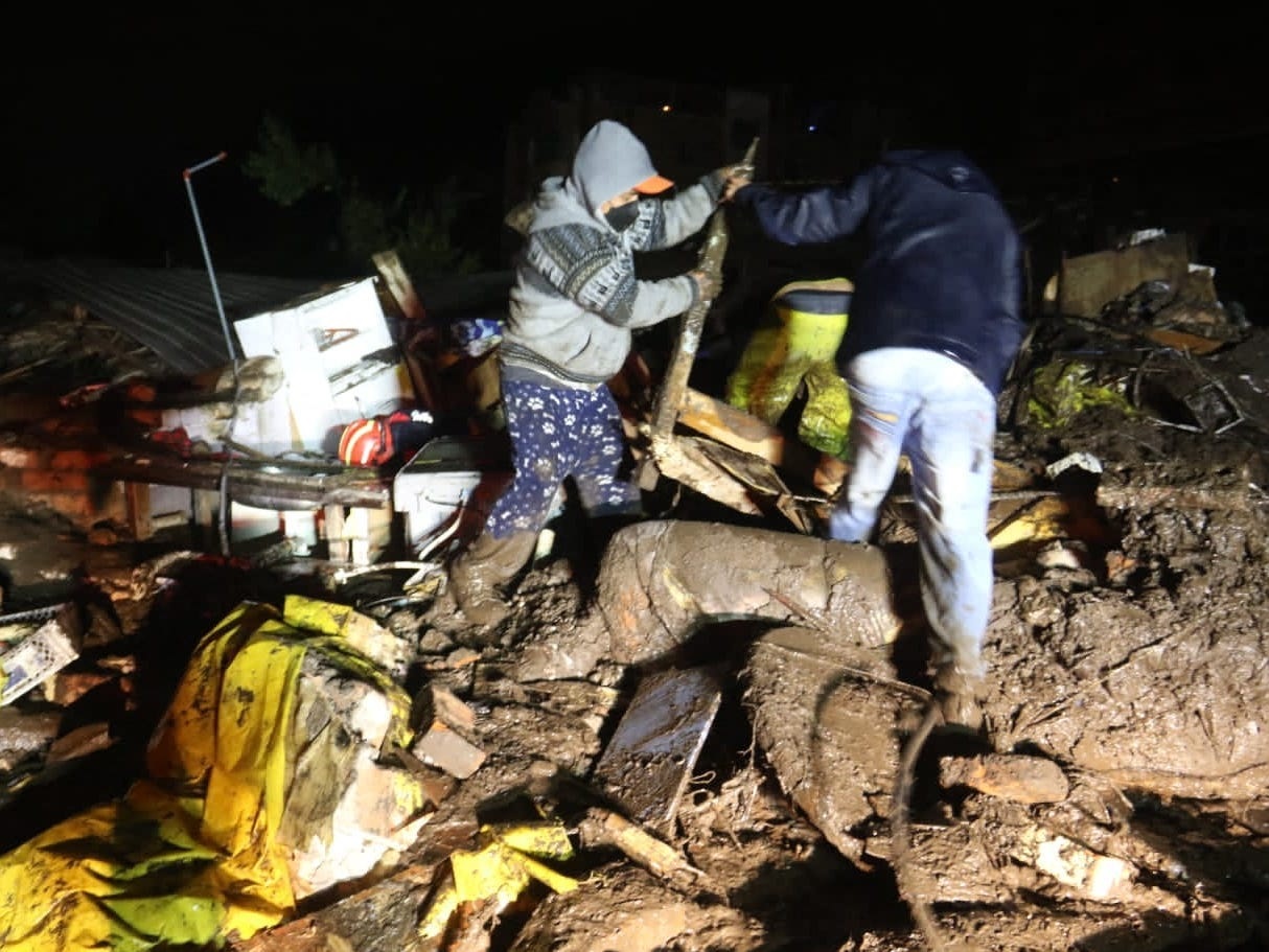 Picture released by Ecuadorean agency API shows people removing debris during the search of victims after a landslide caused by heavy rains in Quito, on January 31, 2022 Photo by API/AFP via Getty Images