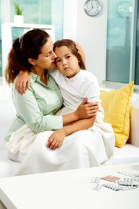 Mother holds her sick daughter from Shutterstock