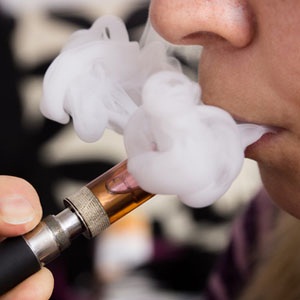 A woman smoking an e-cigarette from Shutterstock. 
