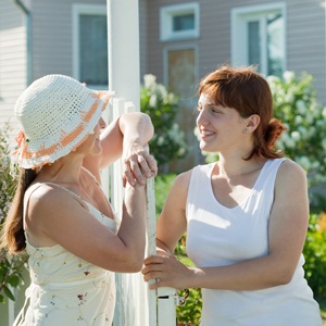 Two happy women talking near fence wicket from Shutterstock
