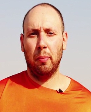 An image from a video released by the Islamic State on September 2, 2014, purportedly shows 31-year-old US freelance writer Steven Sotloff dressed in orange and on his knees in a desert landscape speaking to the camera before being beheaded. Photo: A