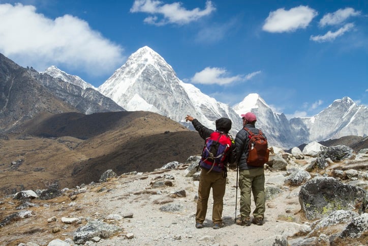 Sherpa guide pointing to Mount Pumori near Lobuche