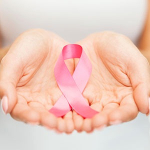 A woman holding a breast cancer awareness ribbon from Shutterstock.