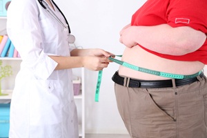 Doctor examining patient obesity on light background from Shutterstock
