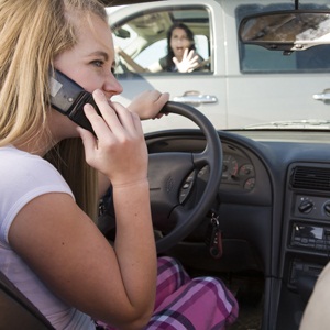 Teenage girl on the phone while driving from Shutterstock
