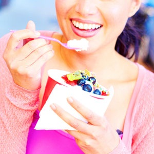 A woman eating yogurt from Shutterstock.