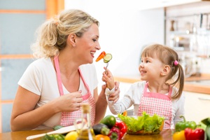 Mother and daughter eating vegetables from Shutterstock