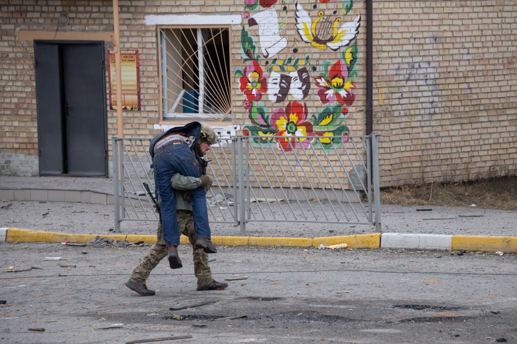A Ukrainian soldier aids a victim of a mortar attack.