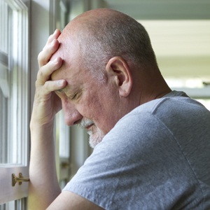 Older man expressing pain or depression from Shutterstock