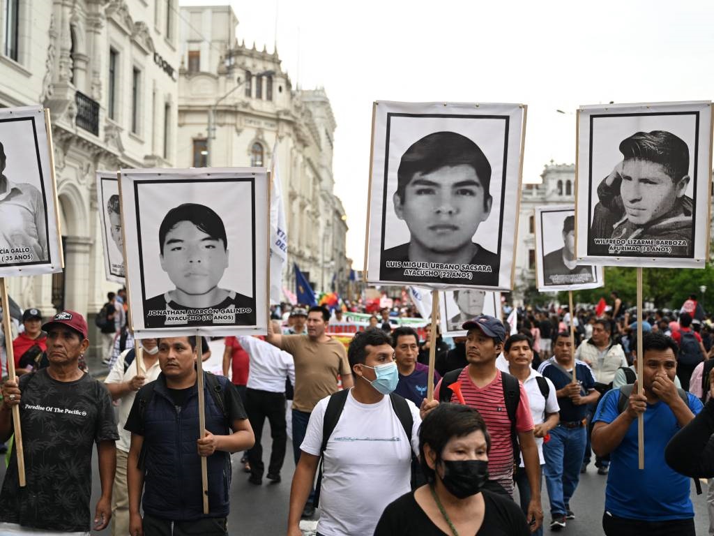 Protestors hold banners with portraits of victims 