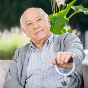 Senior sitting on couch from Shutterstock