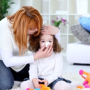 Mom wiping kid's nose from Shutterstock