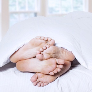 Couple's feet cuddling from Shutterstock
