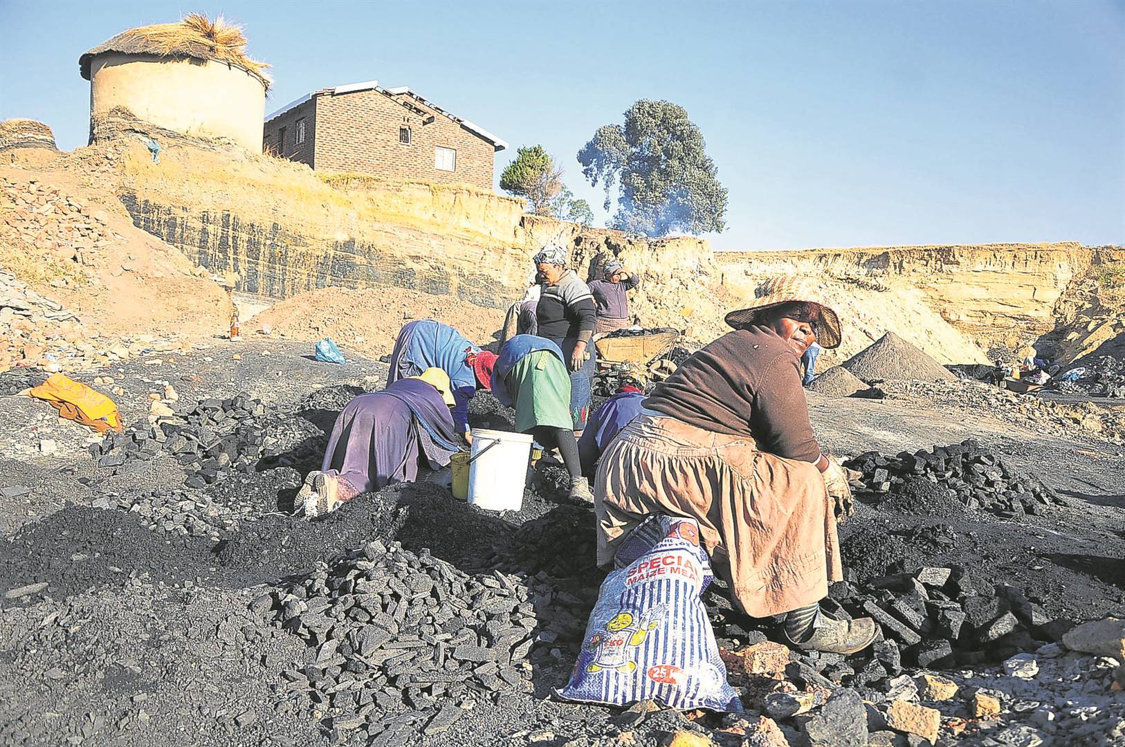 Women sort coal at the Blaauwbosch mining site. Some of them work as teams with their husbands who do the more dangerous work of digging for coal with pick axes and shovels. It is these people who will be the worst affected by the phasing out of coalPHOTO: lucas ledwaba / mukurukuru media