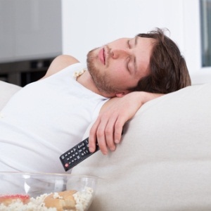 Man lazing in front of TV from Shutterstock