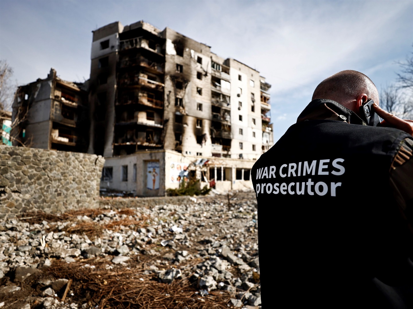 War crime prosecutor's team member speaks on the phone next to buildings that were destroyed by Russian shelling, amid Russia's Invasion of Ukraine, in Borodyanka, Kyiv region, Ukraine April 7, 2022. Zohra Bensemra/Reuters
