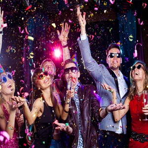 Cheerful people showered with confetti at a New Year's party.