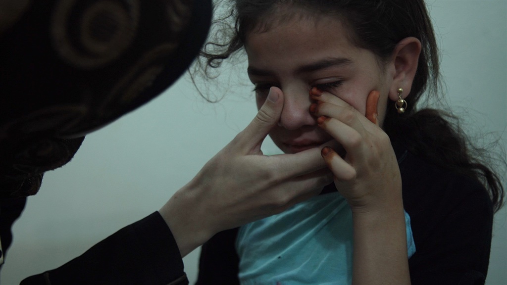 Al Ghouta, Syria - Dr. Amani (R) treats an injured