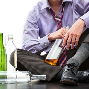 Depressed businessman drinking alcohol on the floor from Shutterstock