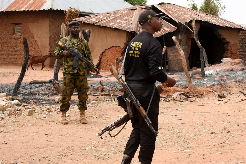 Security personnel stand guard in the Kukawa Village in the Kanam Local Government Area of the Plateau state on April 12, 2022 after resident's houses were burnt down during an attack by bandits.