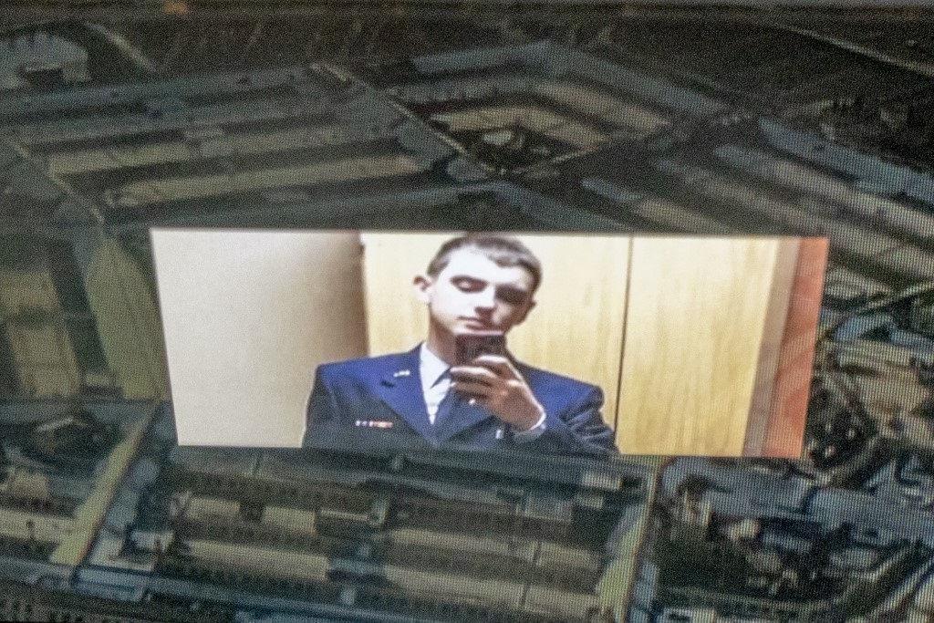Jack Teixeira, reflected in an image of the Pentagon in Washington, DC.