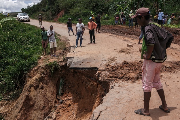 Residents look at the partially collapsed RN25 road in Ranomafana, Madagascar, following the passage of cyclone Batsirai.