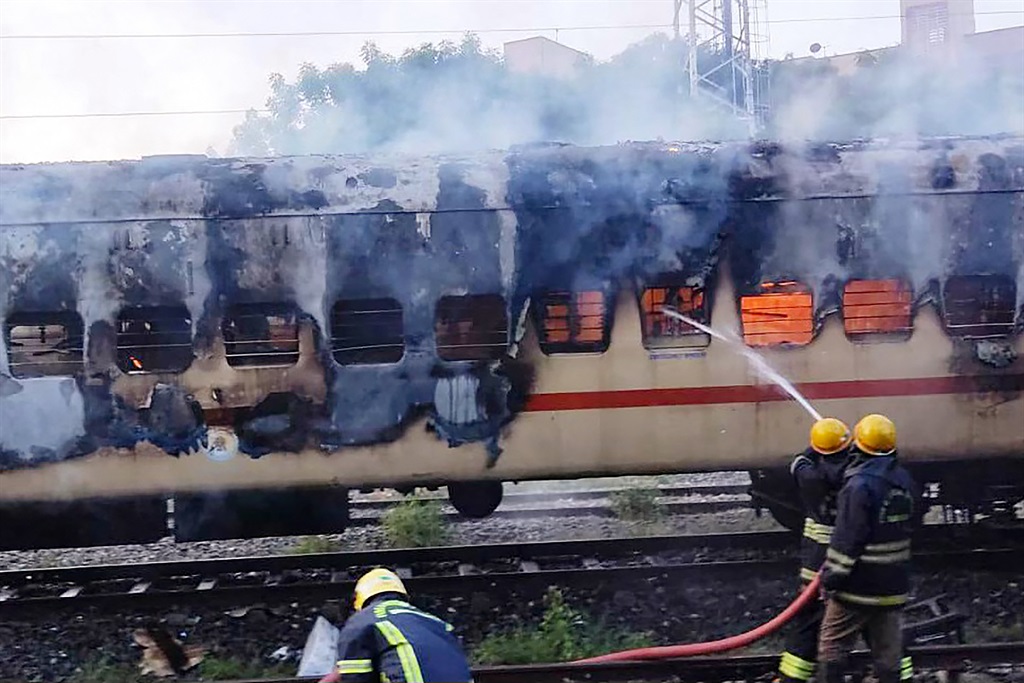 Firefighters try to extinguish a fire which broke out in a train coach parked at the Madurai railway yard, in Madurai on August 26, 2023.