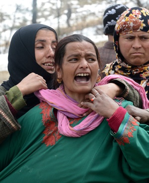 A Kashmiri villager cries as she stands with others during rescue efforts following landslides due to heavy rainfall in the village of Laden at Chadoora some 40km west of Srinagar. (Tauseef Mustafa, AFP)