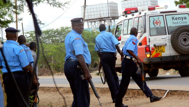 Kenyan police officers take positions outside the Garissa University College as an ambulance carrying the injured going to a hospital, during an attack by gunmen in Garissa, Kenya. (AP)