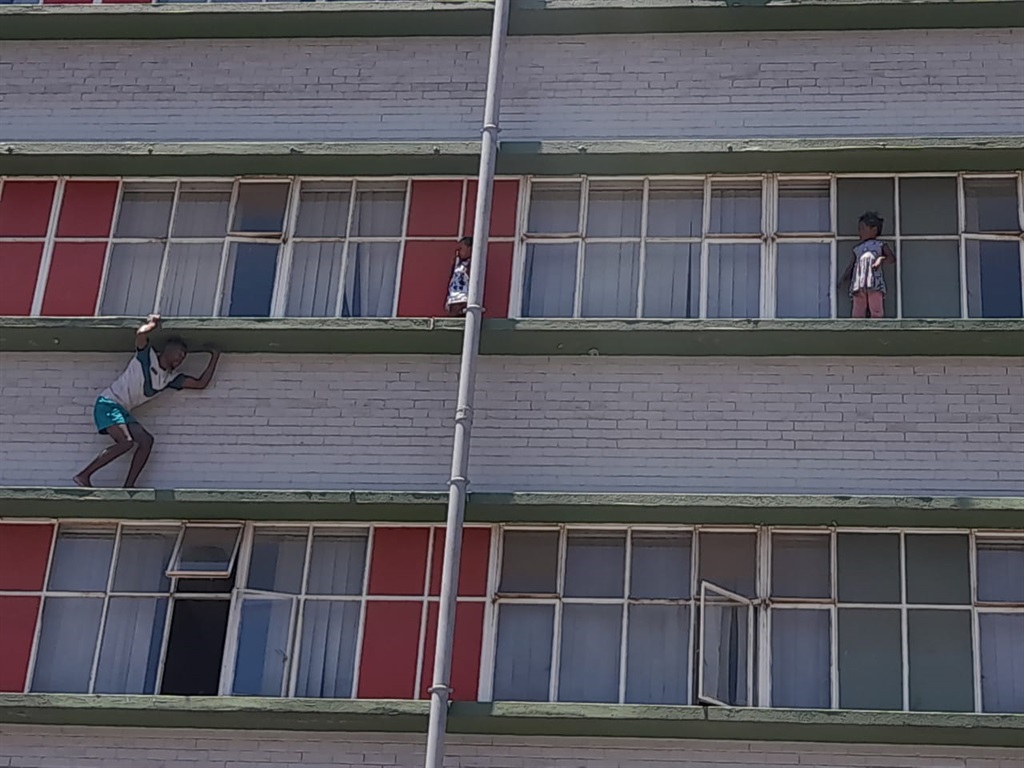 A JMPD officer has rescued two children who were trapped on a ledge after climbing out an open window on the third floor of a Johannesburg building.