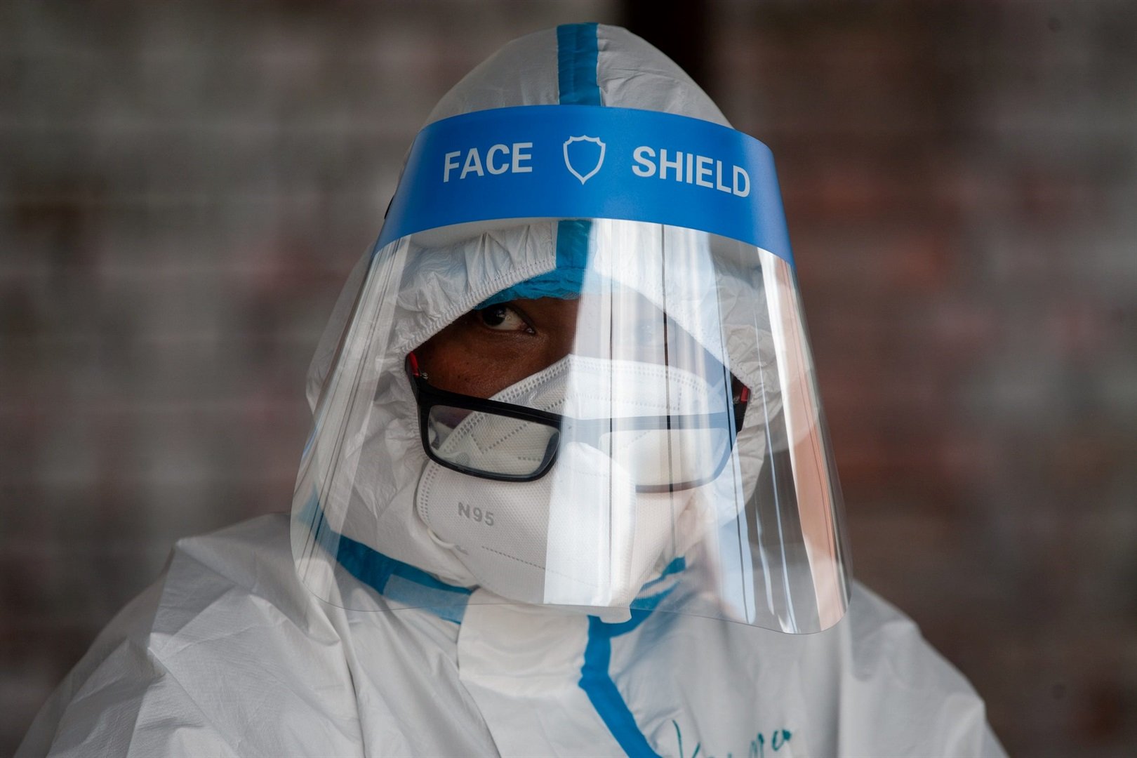 A healthcare worker in Nepal wears a protective suit as a preventive measure during the collection of swab samples.