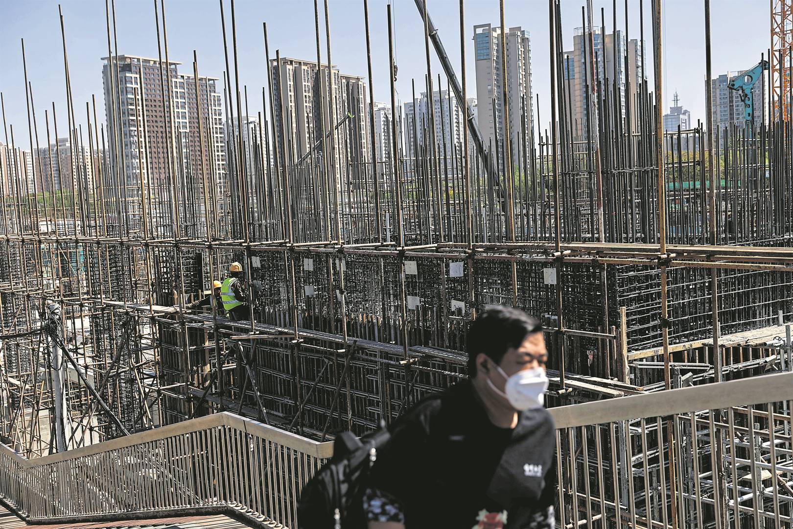 A man walks on an overpass near a construction site of a subway station in Beijing. China’s development has positioned the country as a world leader in infrastructure development.  Photo: Reuters
