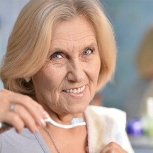 Woman with arthritis brushing her teeth