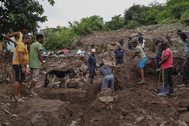 Family members assist with clearing debris in KwaNdengezi after heavy flooding. 