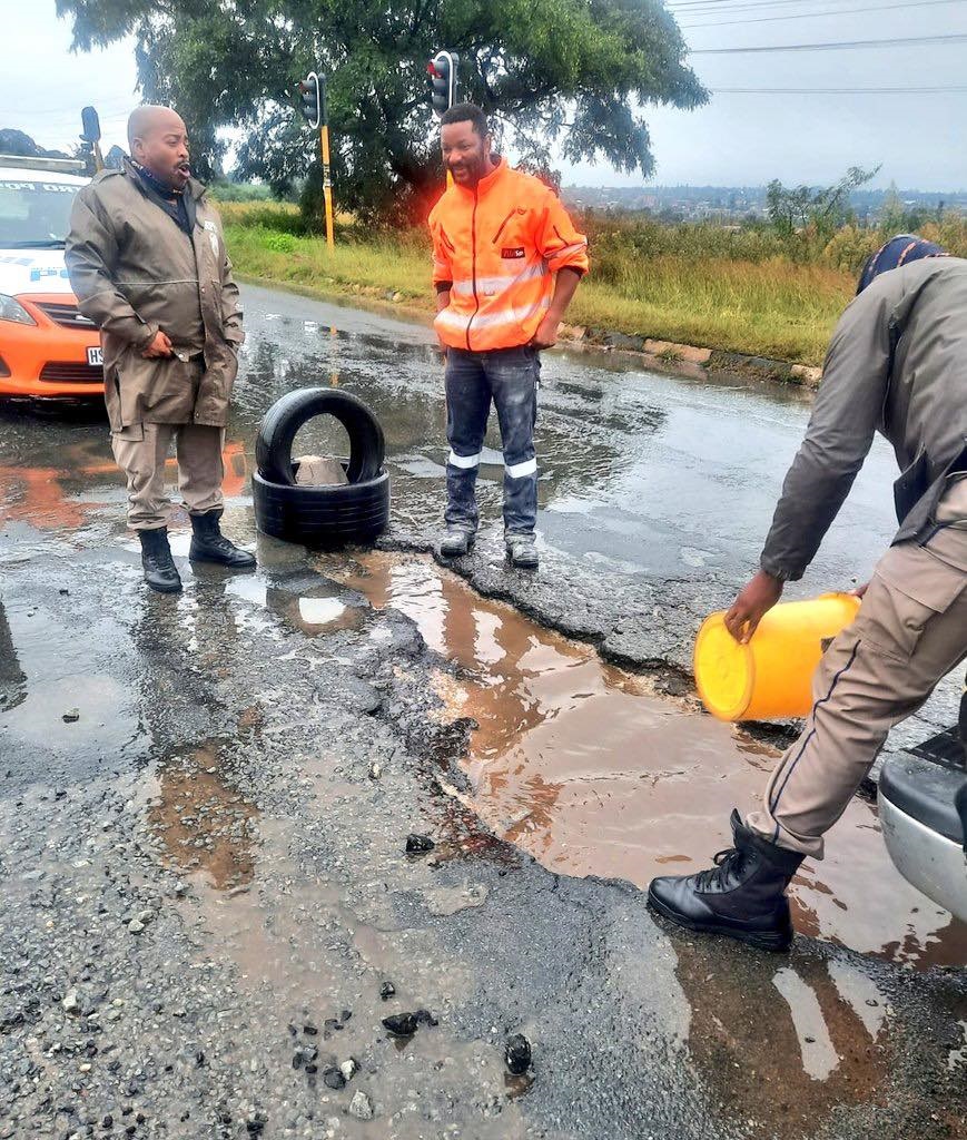 JMPD officers close potholes on Main Reef road.