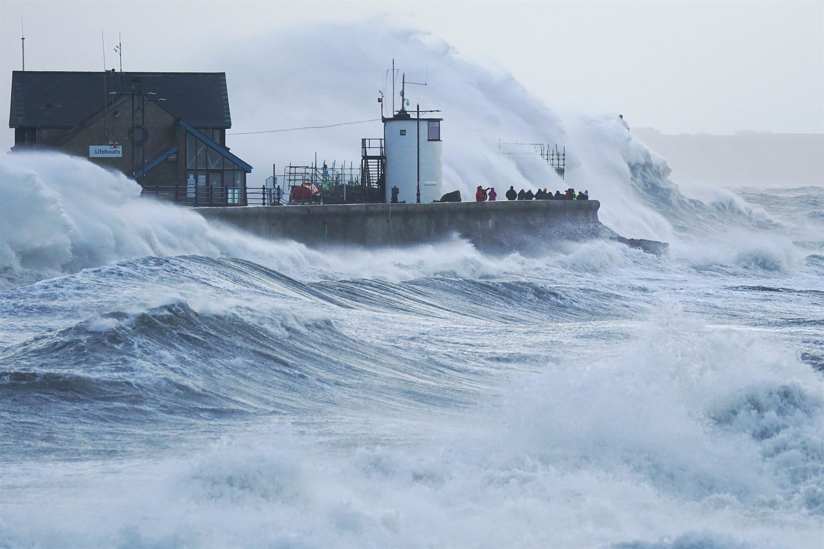 Waves crash against the sea wall and Porthcawl Lighthouse in Porthcawl, Bridgend, Wales, as Storm Eunice hits the south coast. Jacob King/PA Images via Getty Images