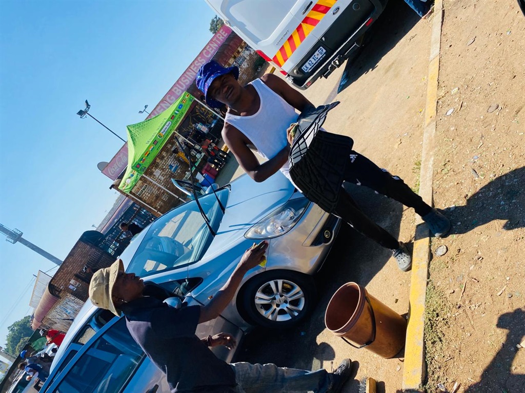 Karabo washes his car with a helper outside the University of Limpopo gates. Photo by Mankaleme Thema